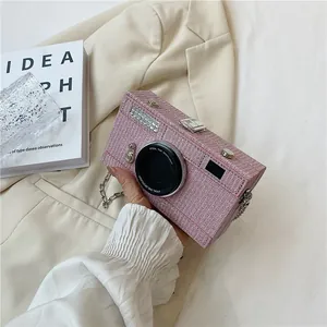 Detailed view of a unique pink tweed camera-shaped crossbody box bag with silver chain