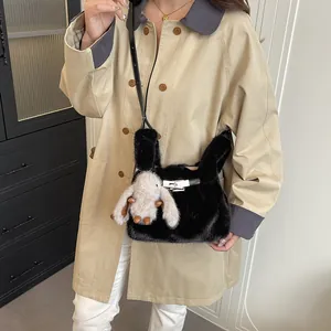 Close-up detail of a black faux fur handbag featuring a cute rabbit plush charm.