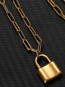 Close-up detail of golden padlock pendant on a paperclip style chain necklace
