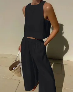 Elegant black two-piece linen set with a sleeveless crop top and wide-leg trousers.