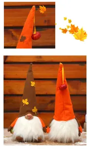 Close-up detail of plush autumn harvest gnomes featuring festive maple leaf accents.