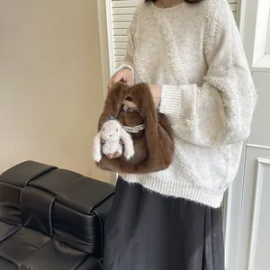 Close-up of a stylish brown faux fur handbag featuring a cute white bunny plush charm