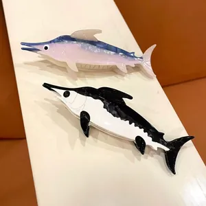 Detailed view of ocean themed cellulose acetate swordfish hair claw clips in two colors