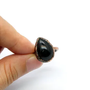 Close-up of antique adjustable ring with teardrop-shaped black stone detail.