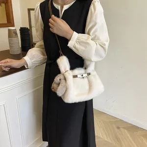 Close-up of white plush crossbody bag featuring a cute grey rabbit charm
