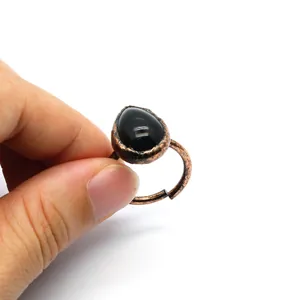 Detailed view of vintage adjustable ring with teardrop black stone and copper band