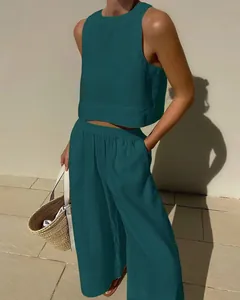 Dark green linen two-piece set featuring a sleeveless crop top and wide-leg trousers.