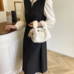Elegant white faux fur handbag with a cute rabbit doll charm for winter.