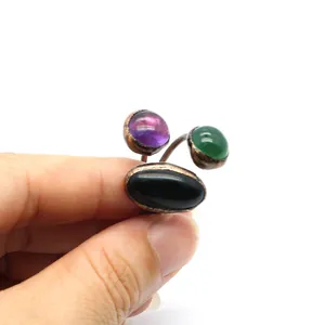 Close-up of a vintage adjustable ring with purple green and black stones
