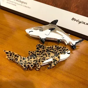 Close-up view of cute shark and leopard shark acetate hair claws on a wood surface