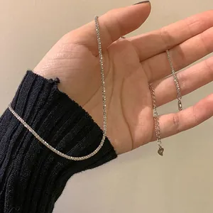 Close-up detail of a minimalist sparkling silver star necklace held in a hand for scale