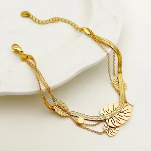 Gold triple-layer bracelet featuring Monstera leaf charms and elegant snake chain design