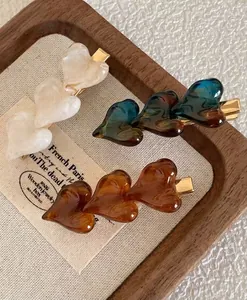 Detail shot of vintage heart-shaped hair clips in cream, tortoiseshell, and amber