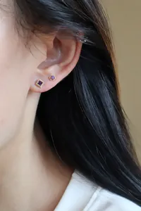 Gros plan détaillé de boucles d'oreilles en argent S925 et or 18K avec zircon violet