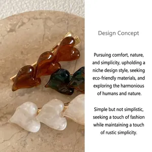 Detail of three heart-shaped resin hair clips with marble texture in various colors.