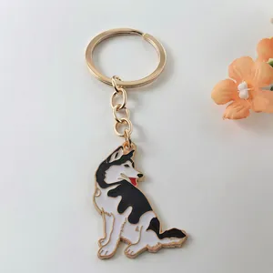 Close-up detail of a cute husky dog enamel metal keychain pendant with a gold ring