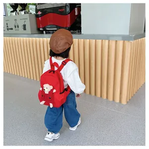 Vue arrière d'un sac à dos rouge pour enfant avec un joli détail d'ours en peluche 3D
