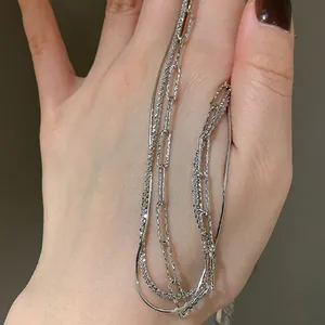 Multi-layered sterling silver necklace featuring sparkling texture and snake bone chain
