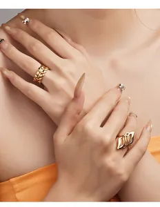 Detailed close-up showing two elegant gold leaf and petal design rings on model fingers