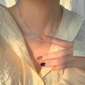 Detail view of a sparkling silver star choker necklace worn by a model in warm light.