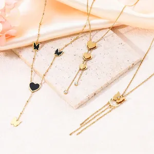 Close-up detail of gold butterfly necklaces and heart pendants on elegant stone block