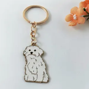 Close-up detail of a cute white enamel dog charm on a premium golden metal keychain