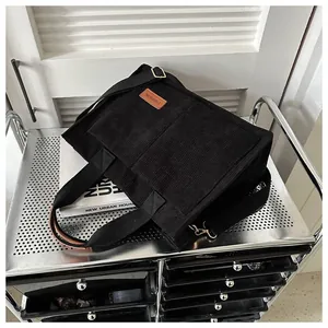 Detailed view of black corduroy large capacity tote bag featuring an adjustable strap