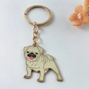 Macro view of a cute cartoon pug dog metal keychain charm with golden hardware finish