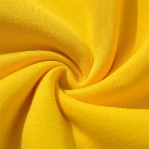 Close-up macro view of the bright yellow soft knitted fabric texture for kids hoodie
