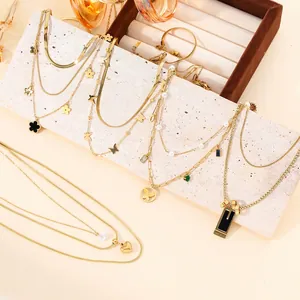 Detailed view of multiple 18k gold-plated stainless steel butterfly and heart necklaces.