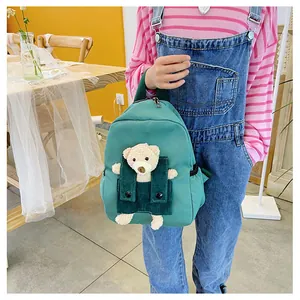 Détail d'un mignon sac à dos vert pour enfant avec ours en peluche 3D et velours