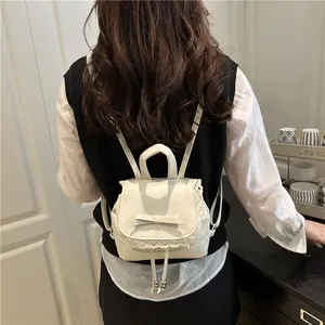Stylish white faux leather mini backpack featuring elegant lace trim and a cute bow detail