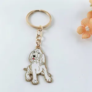 Close-up of cute dog-shaped enamel keychain with gold metal finish and white coating