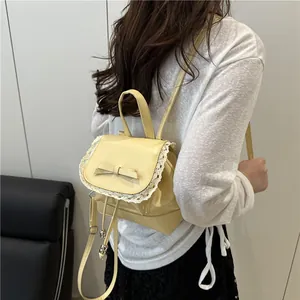 Rear view of a stylish cream oil-leather backpack with lace and bow details