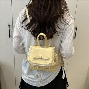 Back view of a chic cream small backpack with elegant lace trim and a cute bow detail