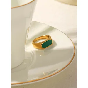 Vintage French style gold stainless steel ring with green enamel oval face on white saucer.