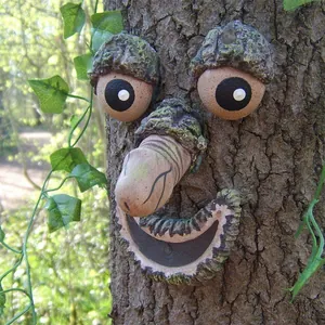 Detailed view of a funny resin tree face sculpture mounted on bark for garden decor.