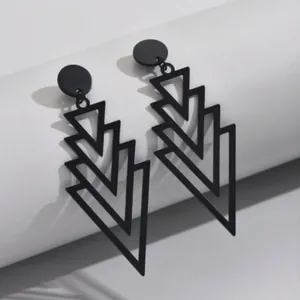 Close-up of black geometric layered triangle drop earrings on a white background