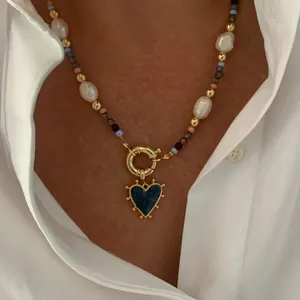 Gros plan d'un collier avec pendentif cœur, perles et perles sur un mannequin