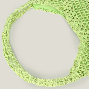 Detail of a lime green handmade crochet hollow woven shoulder bag for summer beach vacation