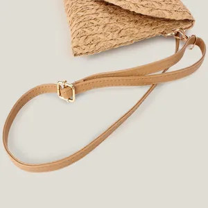 Casual straw woven shoulder bag with adjustable brown leather strap shown in close-up detail