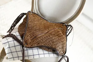 Gros plan sac en paille tressée marron avec fermeture éclair et franges