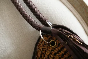Vue détaillée montrant la bandoulière tressée et la texture de corde en papier d'un sac marron