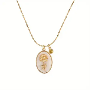 Close-up of a vintage gold oval necklace featuring a delicate flower on pearly base