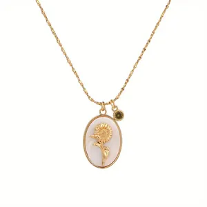 Vintage gold oval necklace with a 3D sunflower motif and green gemstone detail on white