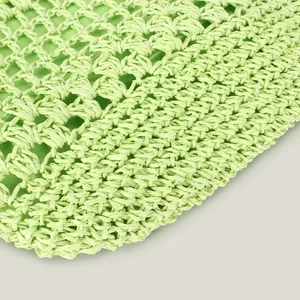 Macro view of light green handmade hollow woven shoulder bag with intricate texture details