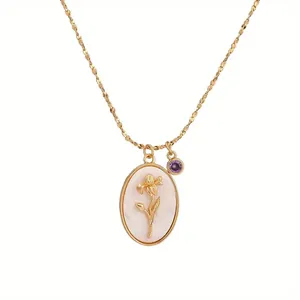 Vintage gold floral necklace with pearlescent oval pendant and purple stone charm detail.