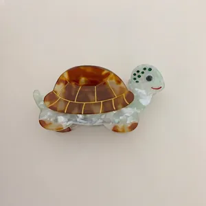 Detailed view of turtle-shaped hair claw clip made of tortoiseshell acetate material