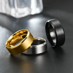 Close-up of matte titanium steel rings in gold silver and black with beveled edges
