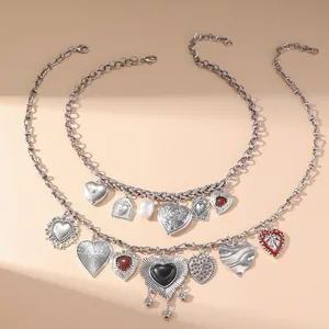 Collana a strati vintage in argento con vari ciondoli a cuore su sfondo beige